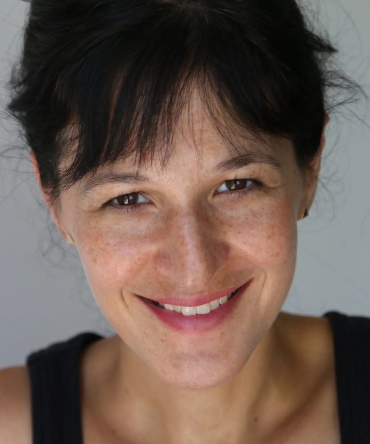 A close-up professional headshot of author Abby Hanlon, smiling warmly and looking directly at the camera against a plain, minimalist background.