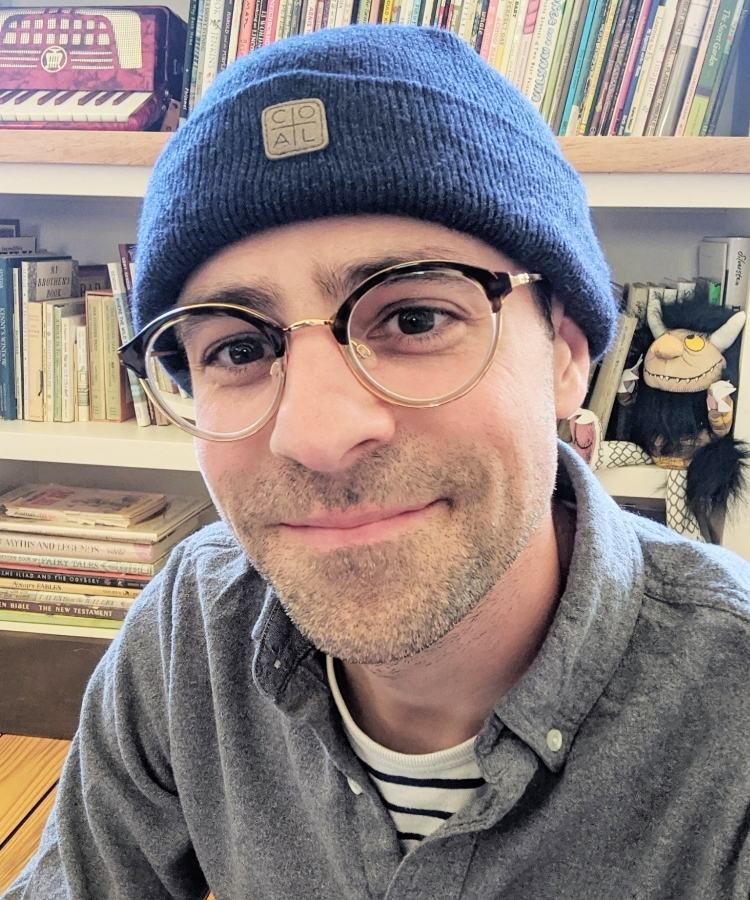 A professional headshot of award-winning author and illustrator Philip C. Stead, smiling warmly in a creative and friendly portrait.